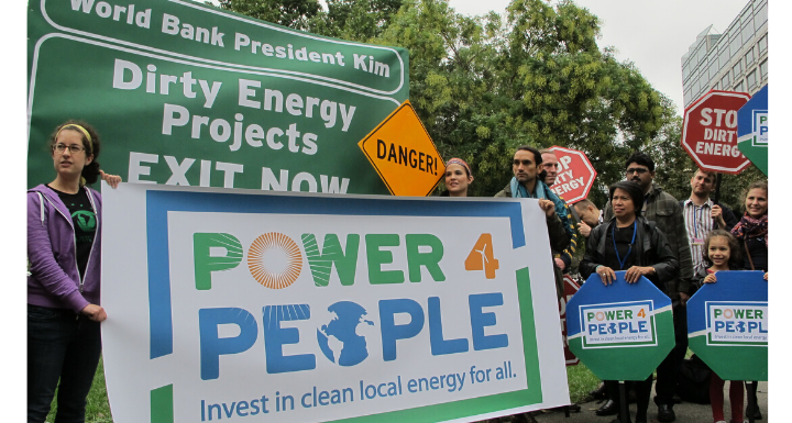 A group of people gathered at a protest with a large sign reading Power 4 People.