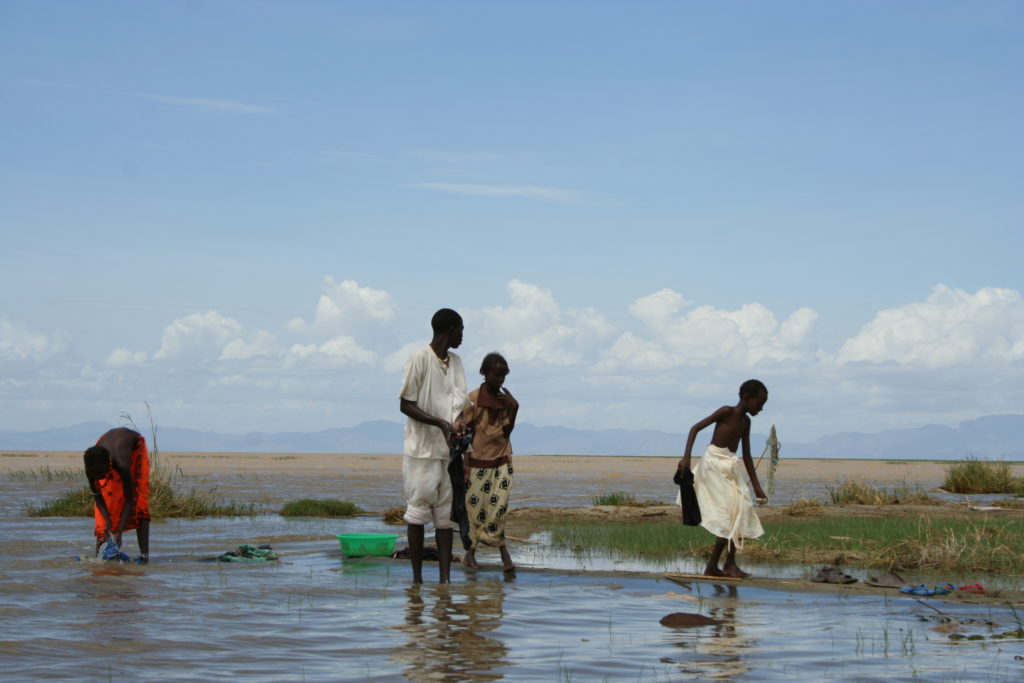Four members of the Omo, washing their clothing in lake Turkana.