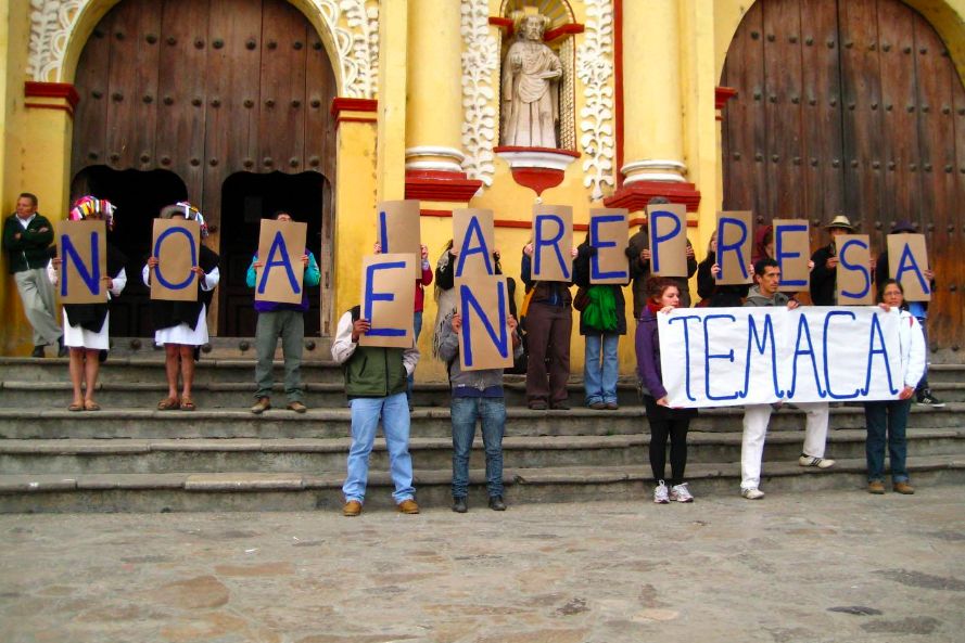 A group of 17 people holding signs to protest a dam in Chiapas, Mexico. 