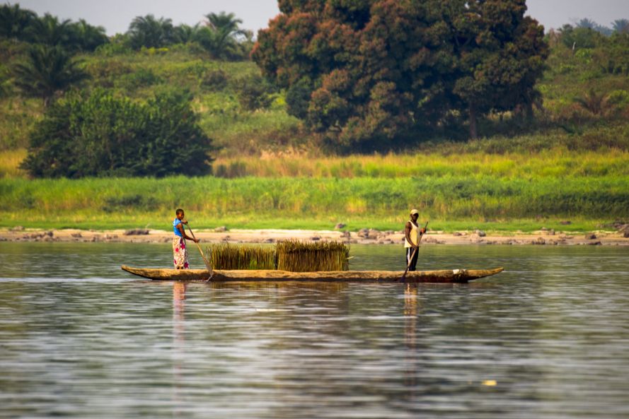 A man and woman in a boat, fishing on the Congo river. 